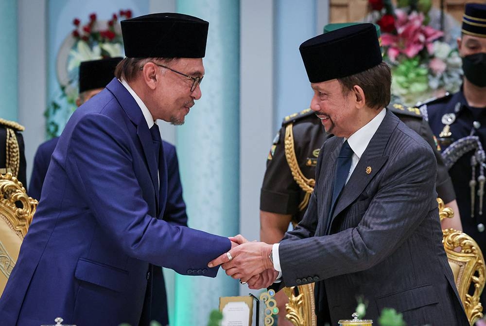 Anwar (kiri) bersalaman dengan Sultan Hassanal Bolkiah pada Majlis Persantapan Rasmi di Istana Nurul Iman hari ini. Foto Bernama