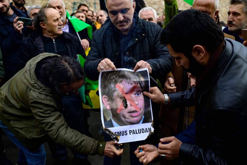 Penunjuk perasaan membakar gambar Rasmus Paludan di kedutaan Sweden di Istanbul, Turkiye. - AFP