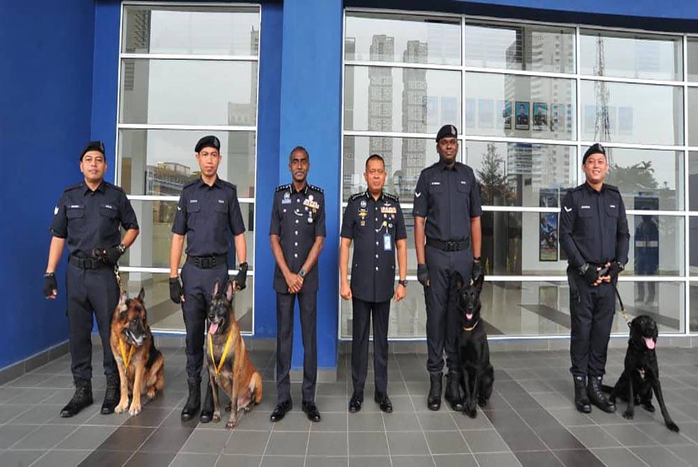 Kamarul Zaman (tengah) bersama petugas dan anjing dari Unit K9 IPK Johor yang menerima pingat penghargaan pada Majlis Perhimpunan Bulanan di IPK Johor, Johor Bahru, pada Khamis.