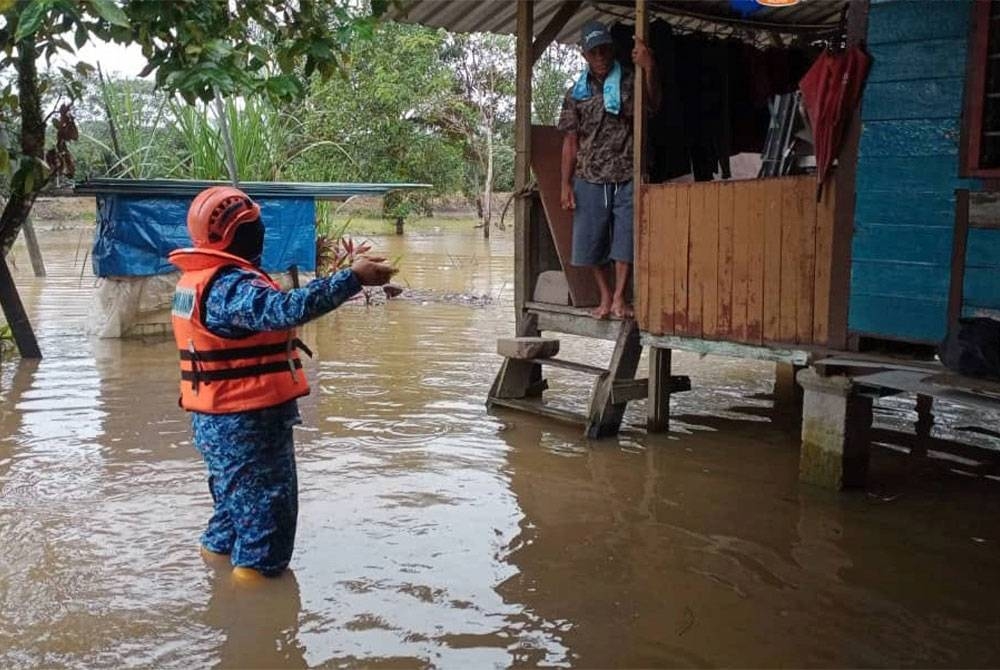 Anggota APM Johor membantu mangsa banjir di Kampung Melayu Raya ditempatkan di PPS di Sekolah Kebangsaan (SK) Melayu Raya, Pontian. - Foto APM Johor