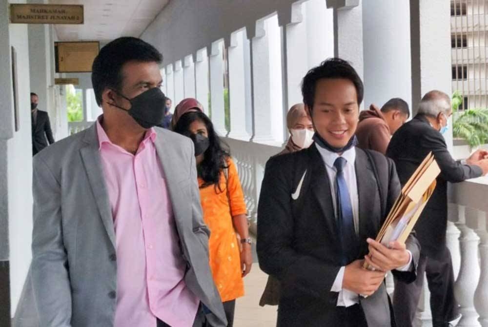 Mohd Ridzuan Abdullah (kiri) hadir di Mahkamah Sesyen Kuala Lumpur pada Khamis dengan memakai kemeja merah jambu, bagi menghadapi 12 pertuduhan mengemukakan dokumen palsu, melibatkan tuntutan berjumlah RM378,000, dua tahun lalu.