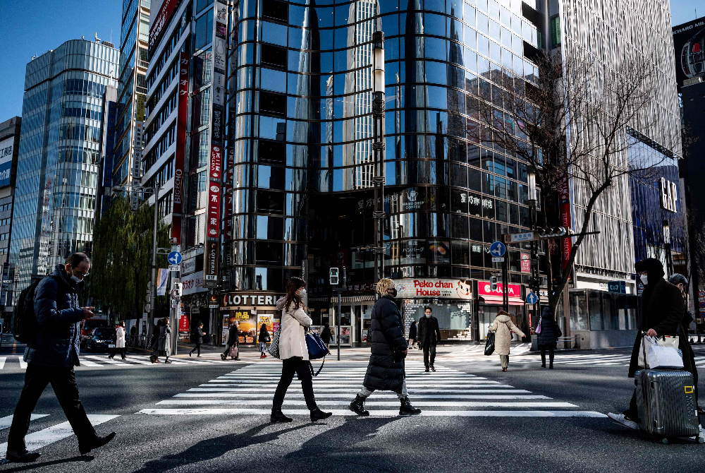 Pejalan kaki melintasi persimpangan di kawasan Ginza di Tokyo pada Khamis. - Foto AFP