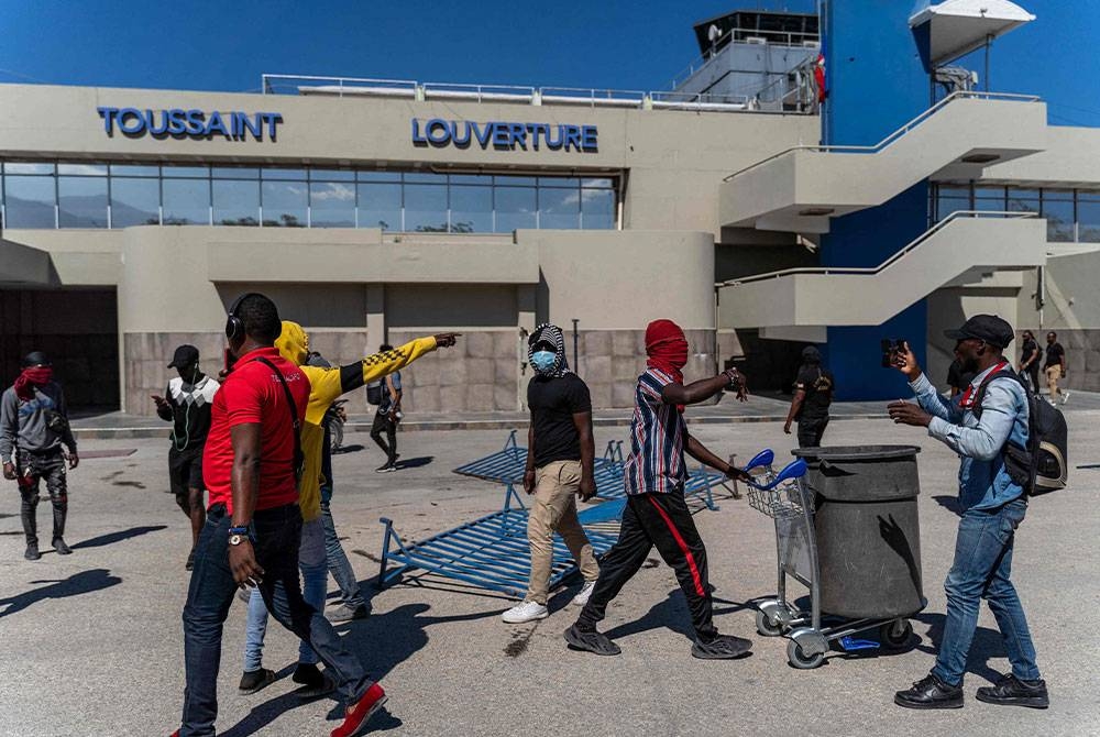 Anggota polis yang mengadakan bantahan di Port-au-Prince turut bertindak menyerbu lapangan terbang di bandar itu. - Foto AFP