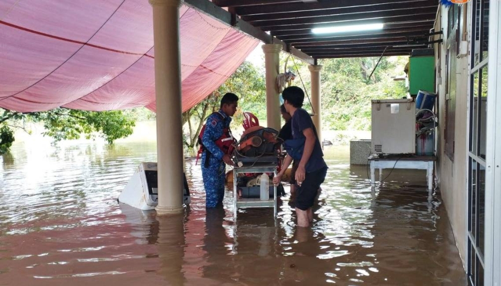 Anggota Angkatan Pertahanan Awam Malaysia (APM) Segamat memantau keadaan banjir di lima kampung di Segamat pada Sabtu. - Foto APM Segamat