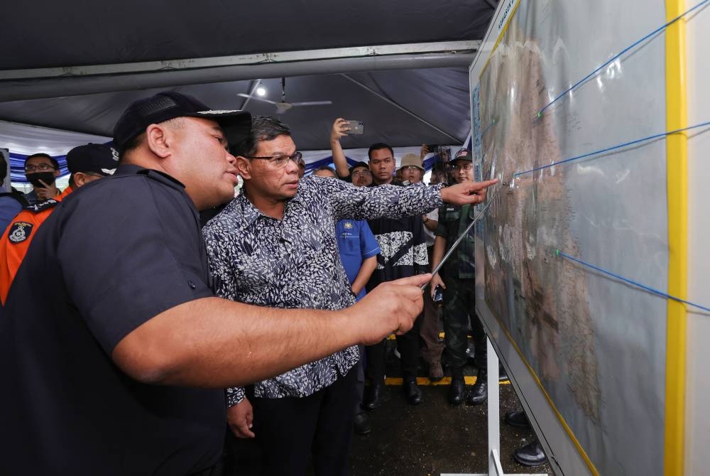 Saifuddin (dua, kiri) mendengar penerangan daripada Ketua Polis Daerah Kluang, Asisten Komisioner Bahrin Mohd Noh (kiri) ketika mengadakan lawatan kerja ke Balai Polis Kahang pada Sabtu. - Foto Bernama