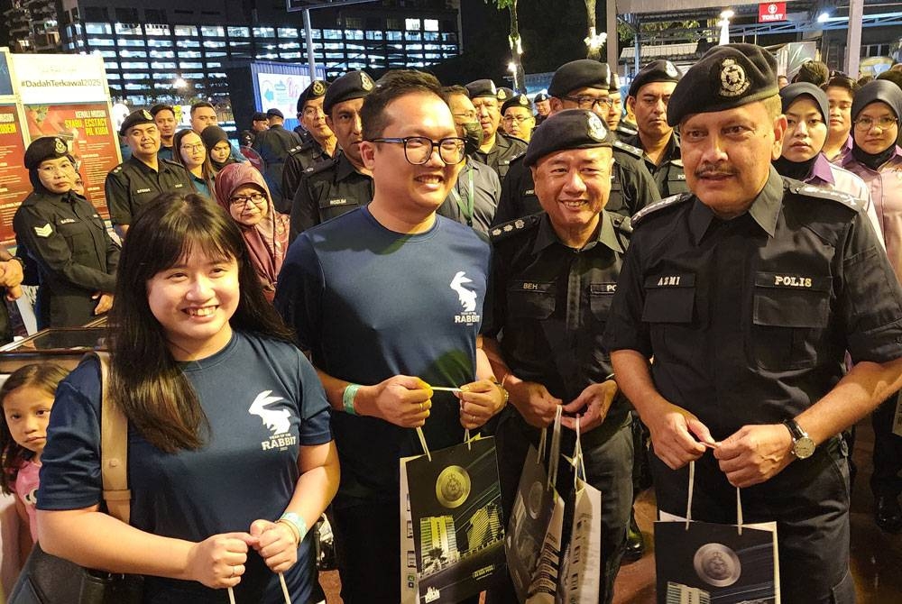 Azmi (kanan) bersama Eng Lai (dua dari kiri) mengambil kesempatan menyampaikan cenderahati kepada orang awam.