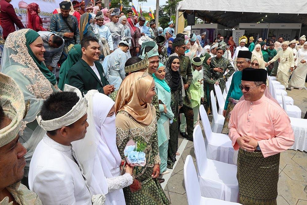 Menteri di Jabatan Perdana Menteri (Hal Ehwal Agama) Datuk Dr Mohd Na&#039;im Mokhtar (kanan) beramah mesra bersama sebahagian pasangan pengantin pada Majlis Walimatul Urus Perdana di Dataran Merdeka sempena Karnival MAIWP 2023 hari ini.
