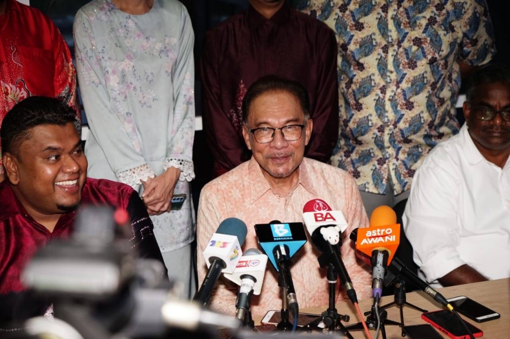 Anwar (tengah) dalam sidang media selepas merasmikan Pusat Khidmat Rakyat Parlimen Tambun di Meru Raya. 