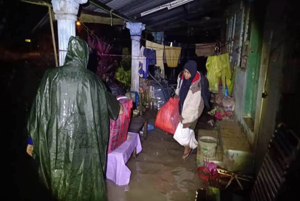 Anggota Angkatan Pertahanan Awam Malaysia (APM) membantu mangsa banjir di Kampung Contoh, Kahang berpindah ke Sekolah Menengah Kebangsaan (SMK) Kahang, Kluang. - Foto ihsan APM Kluang