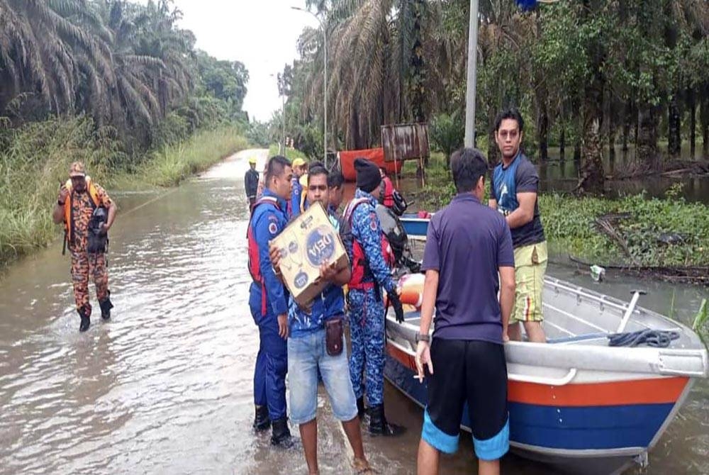 Anggota Angkatan Pertahanan Awam Malaysia (APM) menghantar bekalan makanan menggunakan bot di empat perkampungan Orang Asli di Kahang, Kluang, pada Sabtu. - Foto ihsan APM Kluang