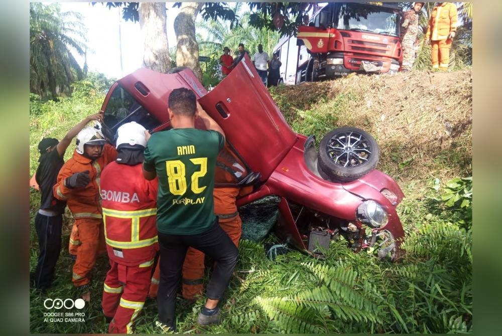 Anggota bomba membantu mengeluarkan mangsa kemalangan di Jalan Beruas-Ipoh di Beruas pada Isnin. - Foto ihsan pembaca