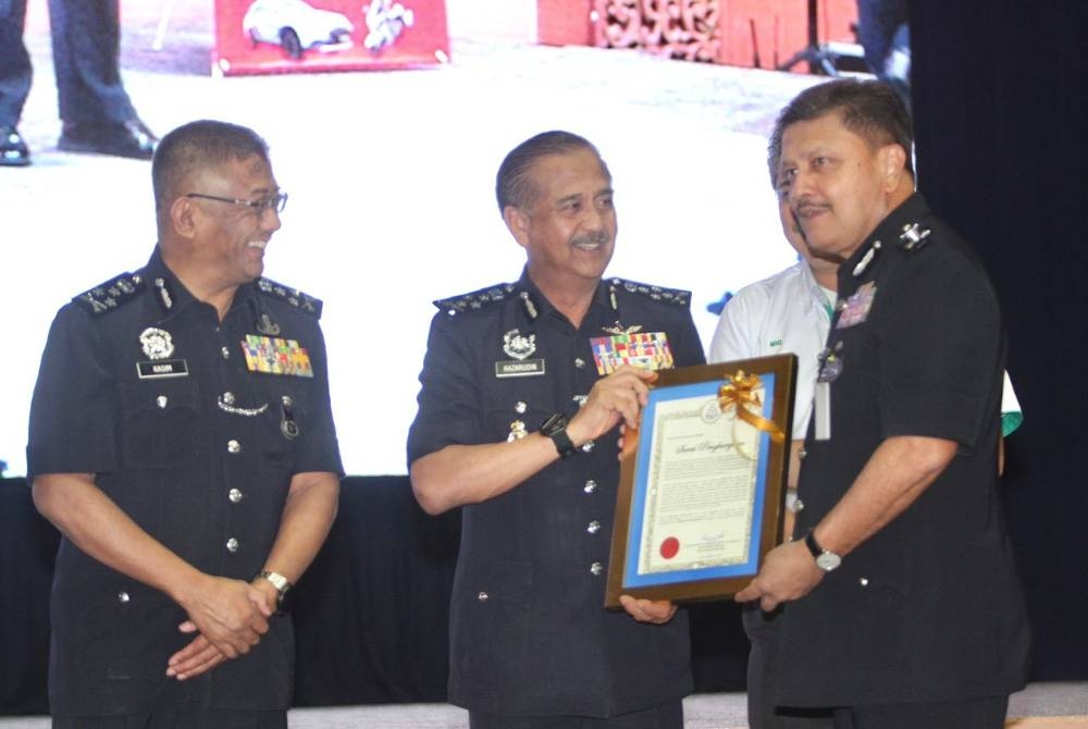 Razarudin (tengah) sijil Anugerah Kontinjen Terbaik kepada Ketua Polis Kuala Lumpur Datuk Azmi Abu Kassim ketika Majlis Penutup Op Selamat 19 sempena Tahun Baharu Cina 2023, di Kuala Lumpur, pada Selasa.