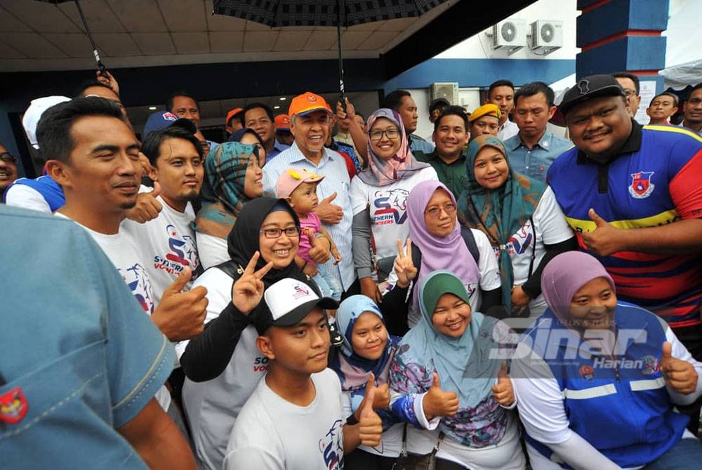 Ahmad Zahid (tengah) bergambar bersama sukarelawan di PPS Dewan Orang Ramai Sri Medan Batu Pahat pada Selasa.