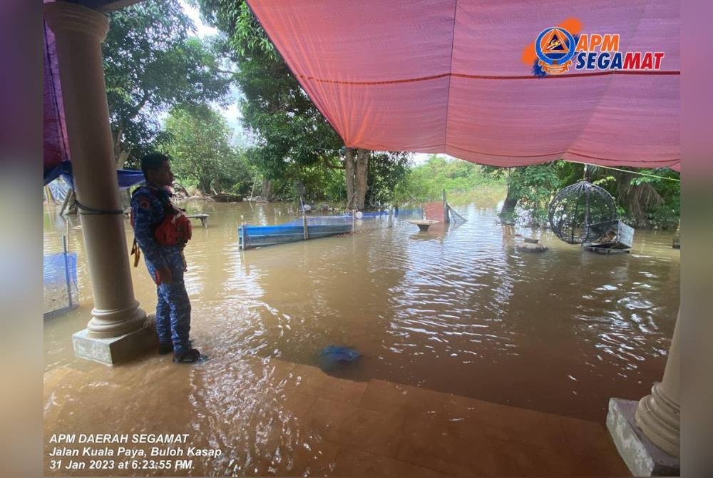 Anggota APM memantau keadaan banjir di Jalan Kuala Paya, Buloh Kasap, Segamat pada Selasa. - Foto ihsan APM Segamat