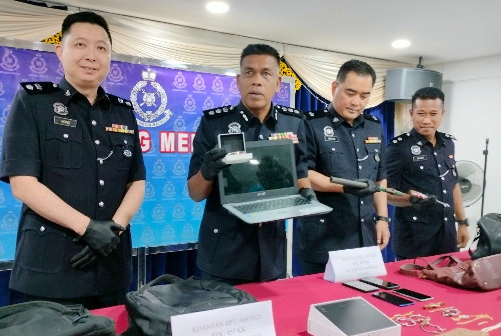 Wan Mohd Zahari (dua dari kiri) menunjukkan barang rampasan pada sidang akhbar berhubung kejayaan tangkapan dua ahli Geng Mirul Dog di IPD Kuantan pada Rabu.