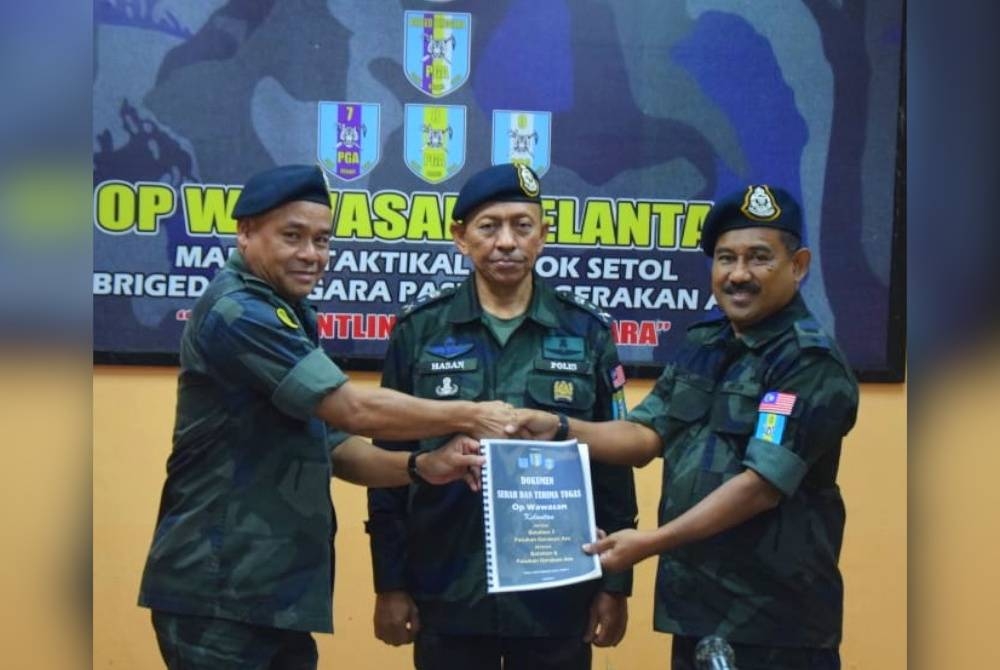 Majlis Serah Terima Tugas Op Wawasan Kelantan antara Batalion 7 PGA Kuantan, Azhari (kiri) dan Shohaiami (kanan) yang disaksikan oleh Hasan Basri (tengah) di Markas Taktikal PGA Lubok Stol, Rantau Panjang pada Rabu.