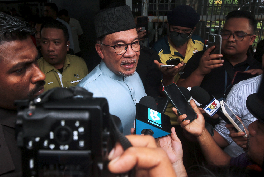 Anwar (tengah) ketika ditemui pemberita selepas menikmati juadah makan tengahari di Warung Pak Salleh, Port Dickson hari ini. 