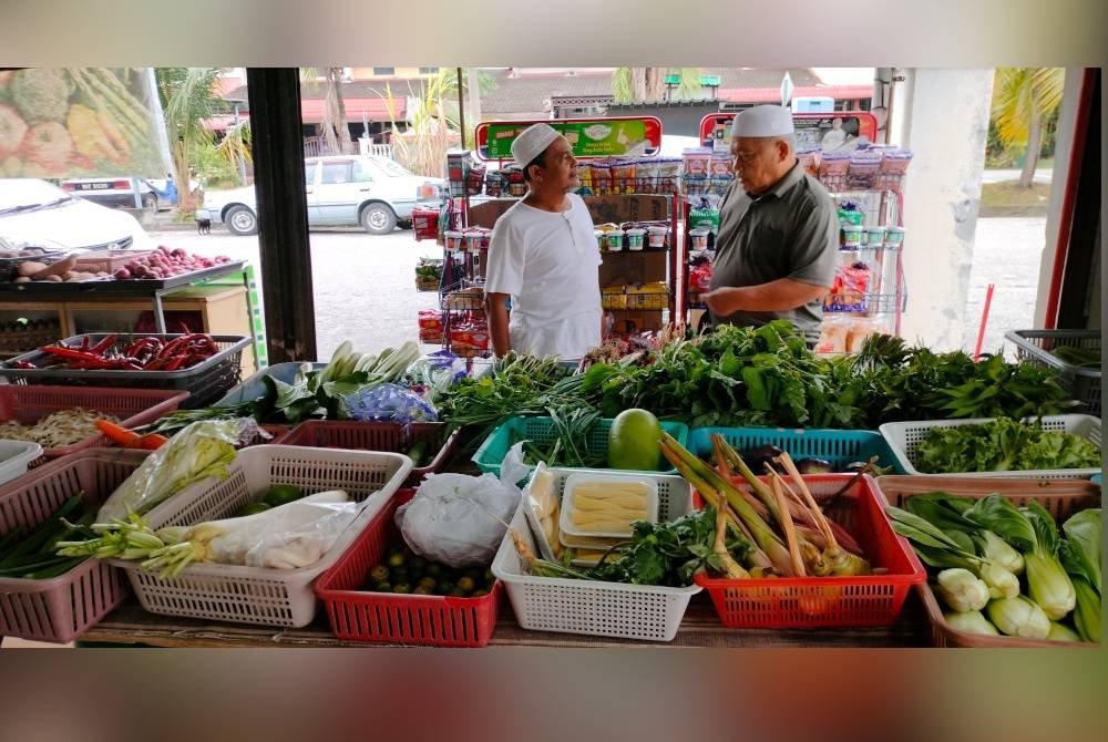 Rosli (kiri) melayan pelanggan di kedainya di Sungai Petani, Kedah.