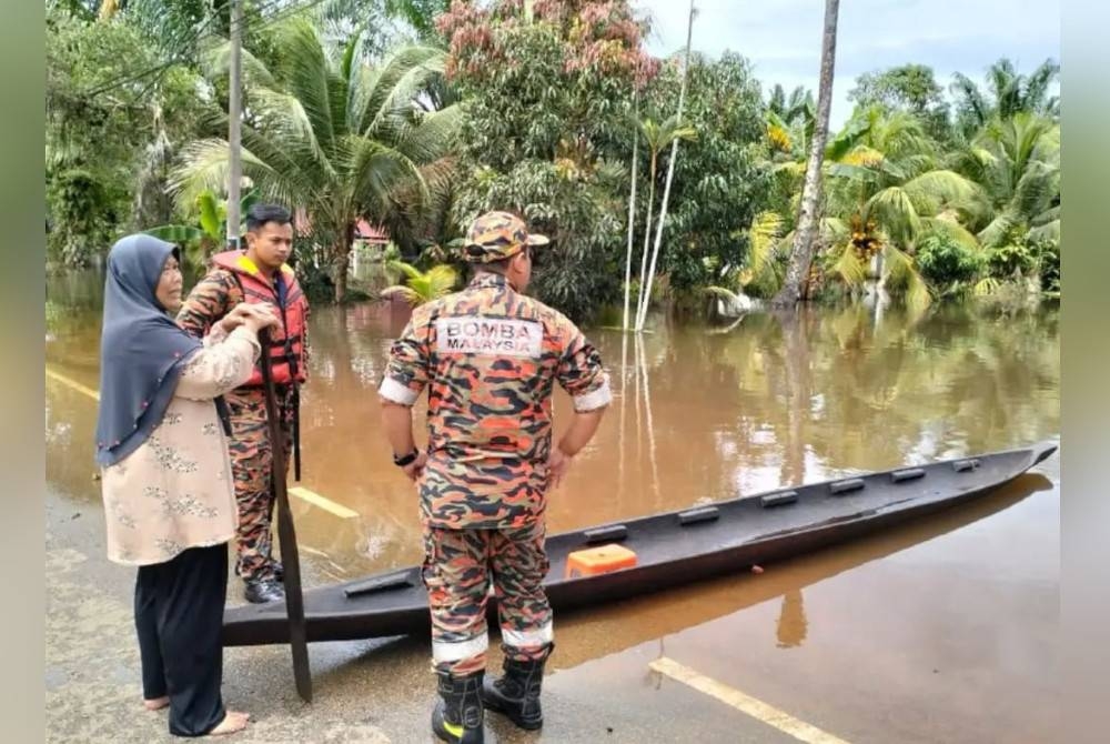 Anggota bomba membantu mangsa banjir di Parit Jayus dan Parit Basri Darat di Yong Peng, Batu Pahat semasa melakukan pemantauan. - Foto ihsan Jabatan Bomba dan Penyelamat Johor