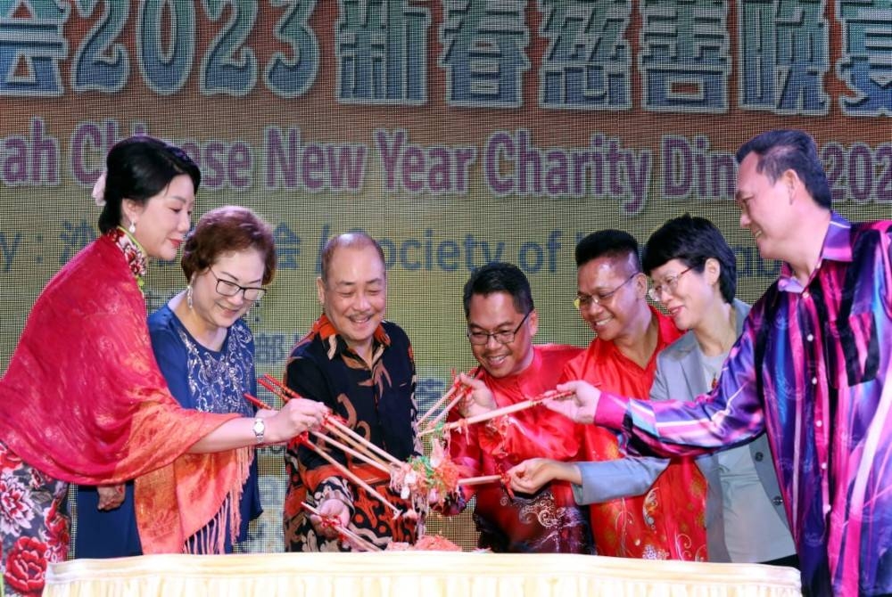 Christina (dua dari kiri) bersama Hajiji (tiga dari kiri) ketika menggaul Yee Sang sempena Majlis Makan Malam Amal Tahun Baru Cina Persatuan Sumber Harapan Sabah di Dewan Hakka, Likas, Kota Kinabalu.