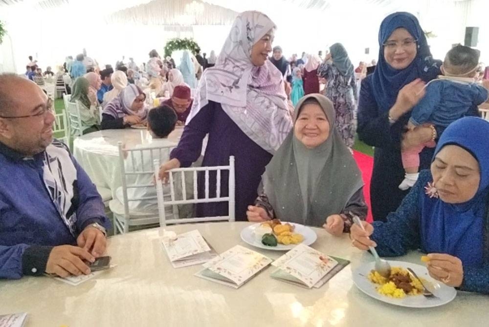 Mohd Asyraf (kiri) dan Tuan Hasmarina (dua dari kiri) beramah mesra bersama ahli keluarga sempena Majlis Kesyukuran dan Perjumpaan Keluarga Besar Haji Nik Ismail dan Hajah Wan Zainab pada Sabtu.