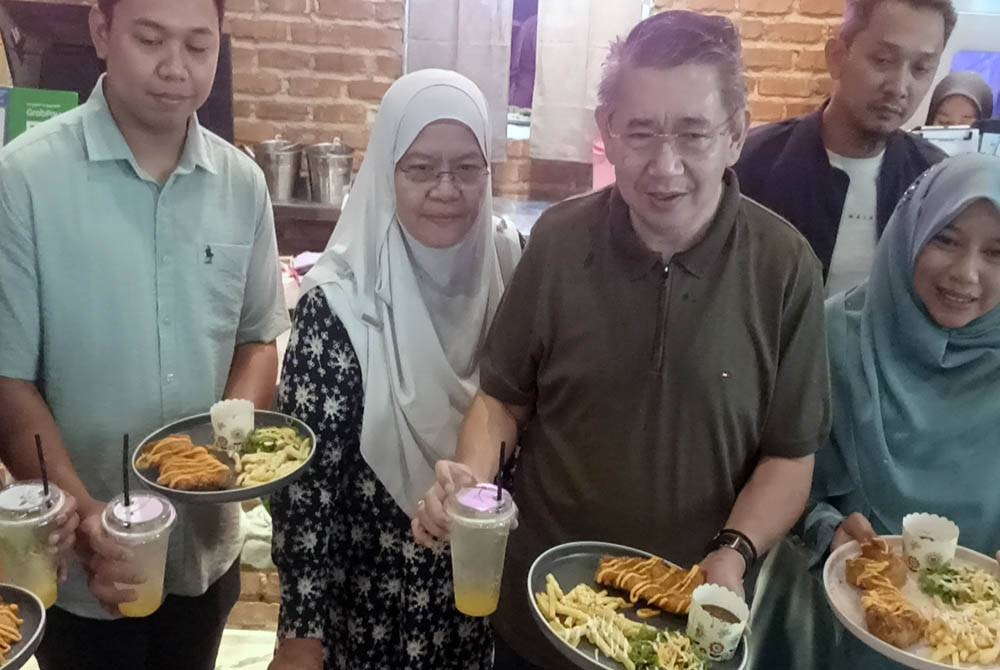 Salahuddin (dua dari kanan) menunjukkan Menu Rahmah RM5 di Samballana Bistro Bandar Dato Onn, Johor Bahru pada Sabtu.