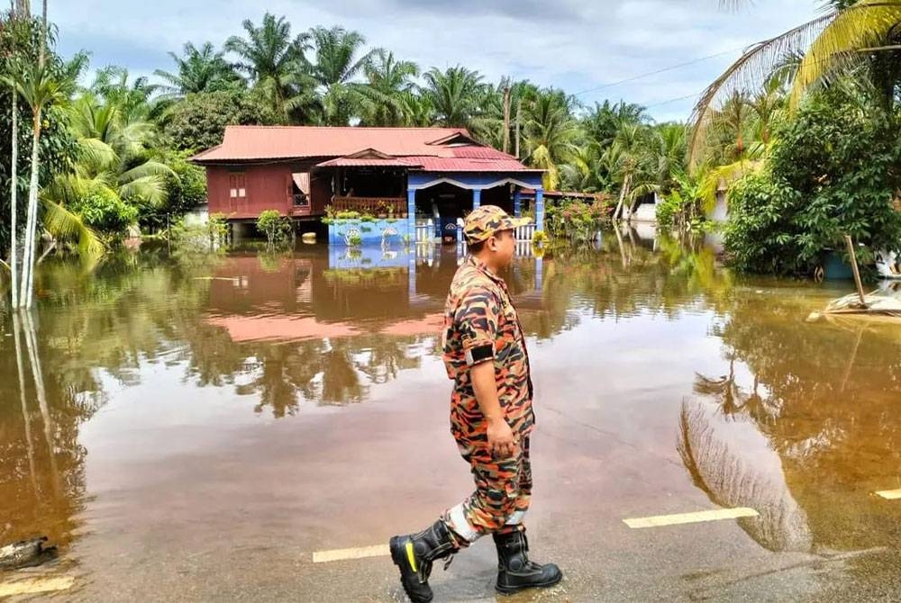 Anggota bomba melakukan pemantauan di kawasan terjejas banjir di Parit Jayus dan Parit Basri Darat di Yong Peng, Batu Pahat