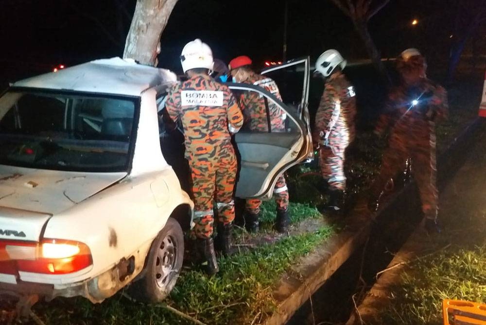 Anggota bomba membantu mengeluarkan mayat mangsa yang tersepit.