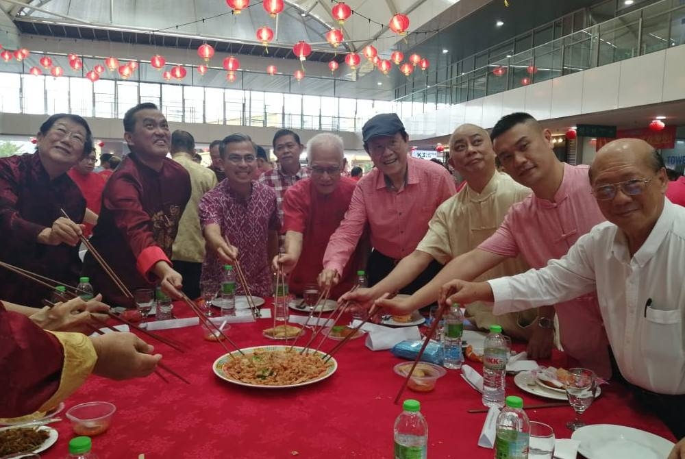 KK Chai (dua dari kiri) dan Fahmi (tiga dari kiri) bersama tetamu khas menggaul yee sang sempena sambutan rumah terbuka Tahun Baharu Cina KLCAH pada Ahad.