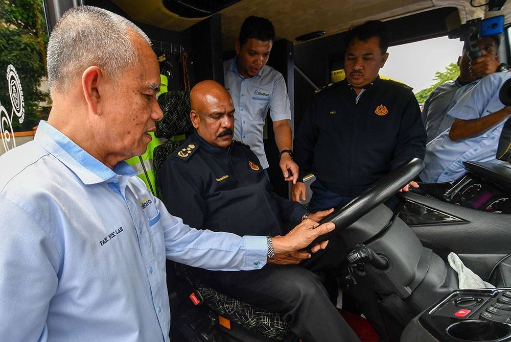 M Janagarajan (dua dari kiri) memeriksa tekanan angin untuk brek bas selepas majlis penutup Kursus Pembangunan Pasukan Kepada Jurupandu Perkhidmatan Bas Ekspres Konsortium E-Mutiara Berhad pada Ahad. - Foto Bernama