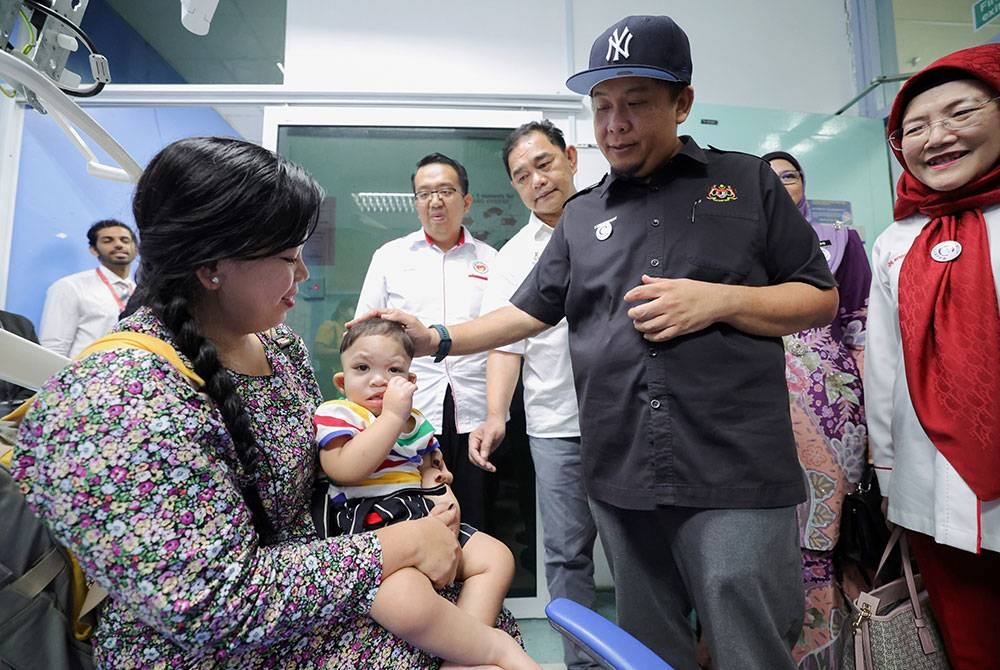 Timbalan Menteri Kesihatan Lukanisman Awang Sauni beramah mesra dengan pesakit rahang Mohamad Alfie Noo Lokman sewaktu melawat bilik rawatan selepas Grand Smile Operation Initiative 2023 di Hospital Lahad Datu. Foto Bernama.