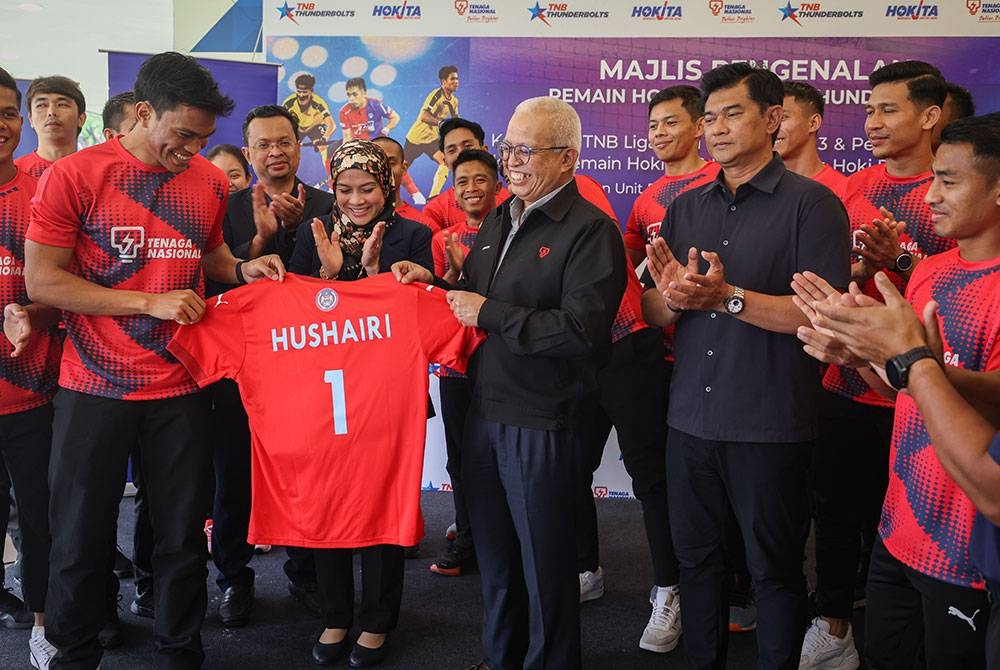 Kapten TNB, Syed Mohamad Syafiq Syed Cholan (kiri) menyerahkan jersi pasukan TNB kepada Ahmad Hushairi selepas majlis pengenalan pasukan TNB dan TNB Thunderbolts sempena Liga Hoki Malaysia 2023. - Foto Bernama