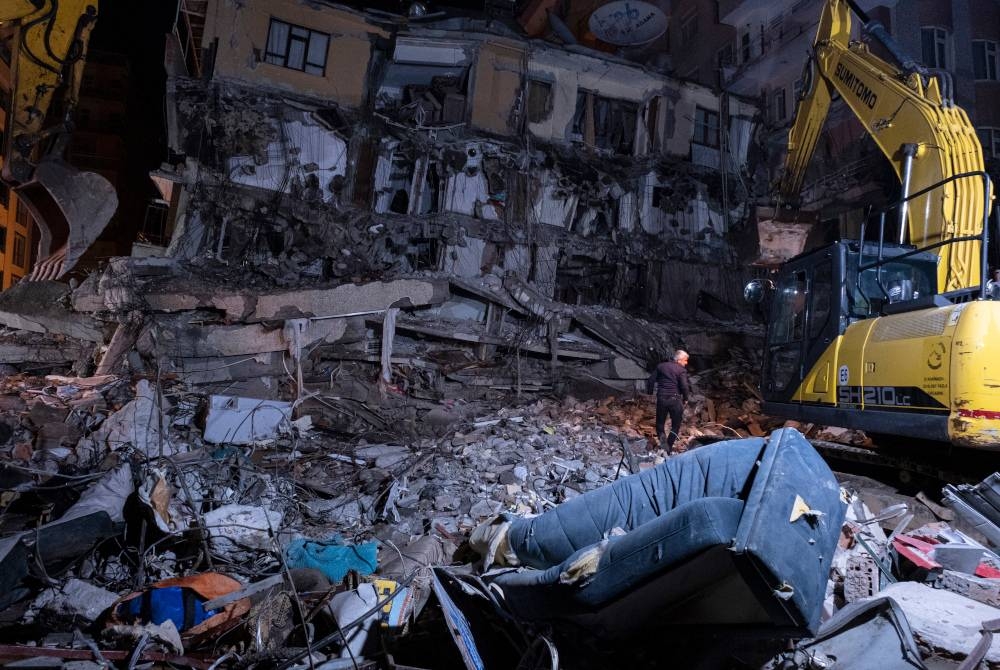 Seorang lelaki memeriksa bangunan yang runtuh selepas gempa bumi kuat di Diyarbakir, Turkiye. - Foto EPA