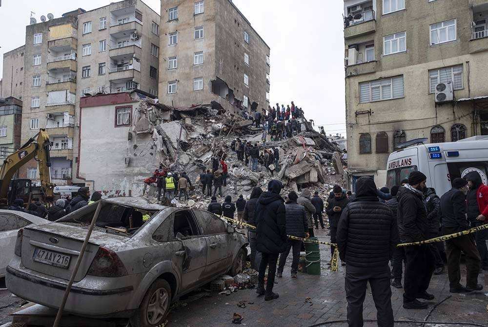 Anggota kecemasan mencari mangsa di tapak bangunan yang runtuh selepas gempa bumi di Diyarbakir, tenggara Turkiye. - Foto EPA