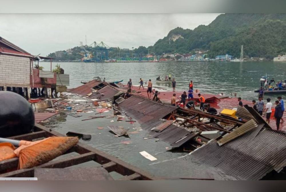 Orang ramai berdiri di atas bumbung kedai yang runtuh di pelabuhan selepas gempa bumi melanda. - Foto AFP