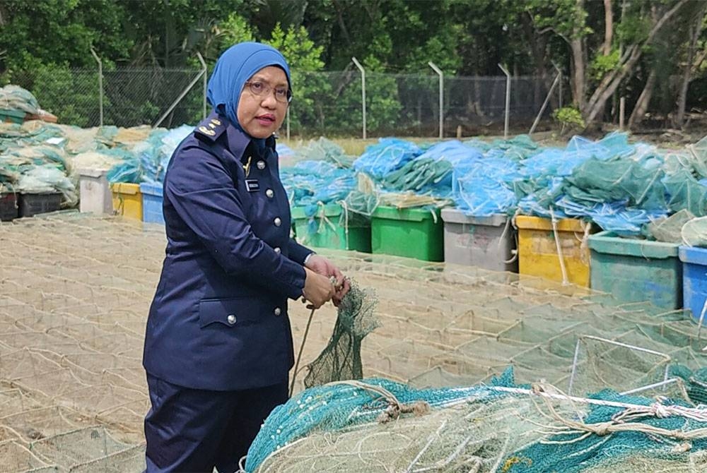 Noraisyah menunjukkan sebahagian bubu naga dirampas pada sidang akhbar di Pusat Tahanan Vesel Kuala Selangor di sini pada Jumaat.