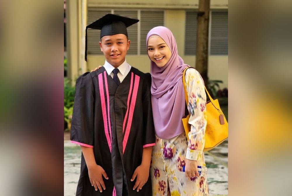 Sari Yanti berkongsi foto di samping anak lelakinya, Barr Al-Aliy, 13, yang lengkap berpakaian akademik iaitu jubah dan mortarboard.