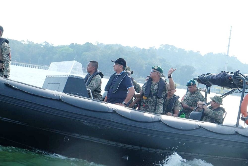 Adly (tengah) ketika menaiki bot Kevlar menuju ke Pangkalan Hadapan Carilamat (PHC) di Pulau Besar pada Jumaat.