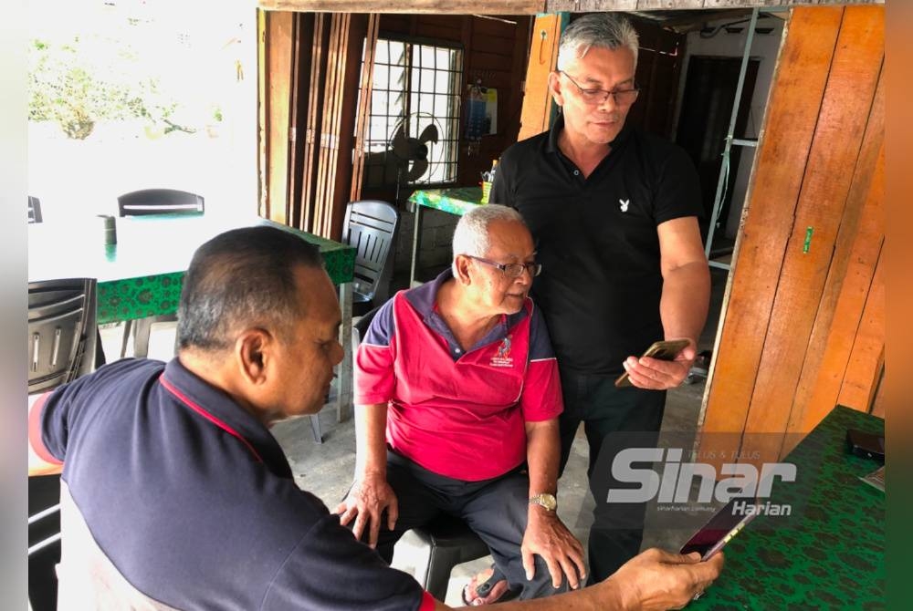 Mustafa (tengah), Husni (kanan) dan seorang lagi pengguna, Shamsudin Daud, 65, mencuba memuat naik MyJPJ.