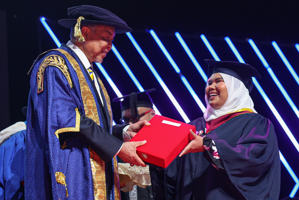 Ahmad Zahid menyampaikan Anugerah Canselor kepada pelajar jurusan Teknologi Kejuruteraan, Maryam Farzana Mohamad Sokri pada Majlis Konvokesyen ke-19 UniKL di Pusat Dagangan Dunia pada Sabtu. - Foto Bernama