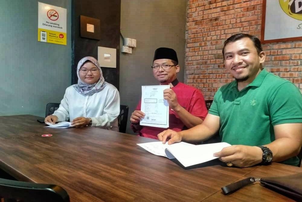 Shukri (tengah) menunjukkan dokumen berkaitan dakwaan penyelewengan wang zakat MAINS. - Foto Shukri