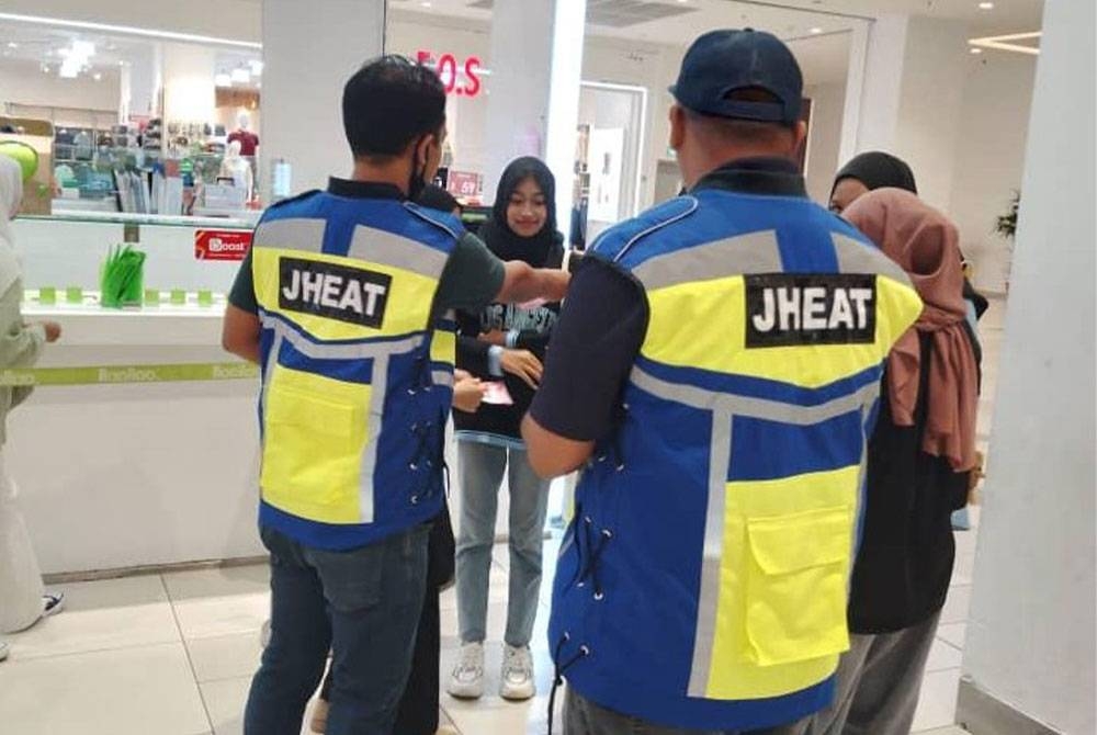 Pegawai penguatkuasa syariah mengedarkan risalah kempen &#039;Say No To Valentine Day&#039; kepada orang ramai. Foto: JHEAT