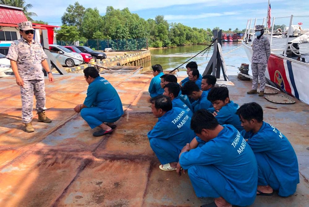 Syed Nor Adli (kiri) melihat tekong dan awak-awak warga Vietnam yang ditahan dalam serbuan bersepadu menerusi Op Naga Barat, Kuda Laut dan Damai.