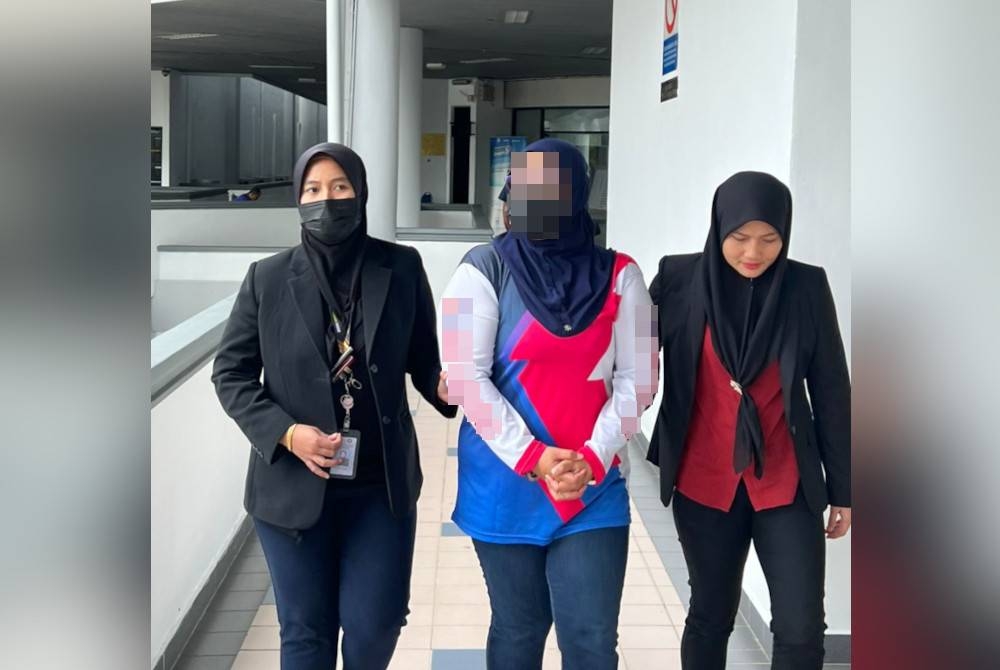 Suspek (tengah) dibawa untuk mendapatkan perintah reman di Mahkamah Majistret Ayer Keroh, Melaka pada Sabtu.