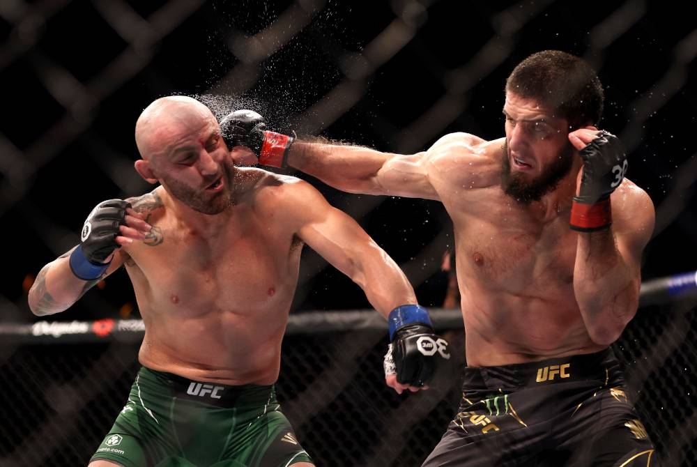 Islam (kanan) melakukan tumbukan ke arah Volkanovski dalam saingan lightweight UFC di Perth. - Foto EPA