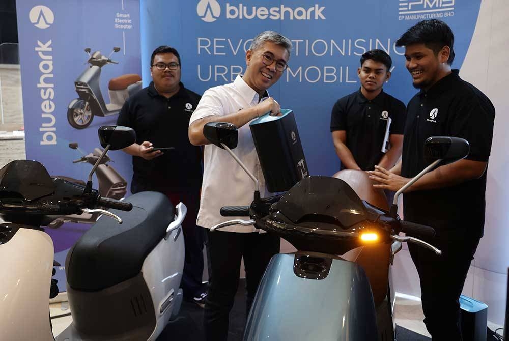 Tengku Zafrul (dua dari kiri) melihat motosikal elektrik pada perasmian Persidangan Kenderaan Elektrik 2023 di Menara MIDA pada Selasa. - Foto Bernama