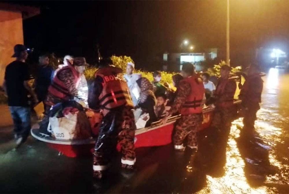 Pasukan bomba membawa mangsa banjir di Kampung Pasir, Temoh untuk dipindahkan ke PPS. - Foto Bomba Perak