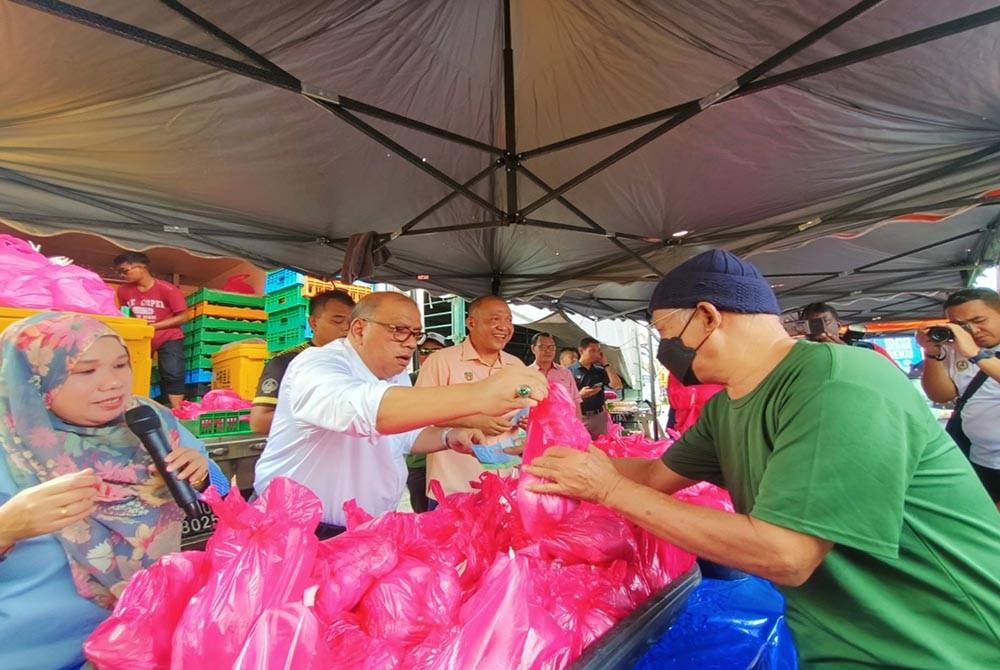 Mohd Zolkafly membantu jualan ayam pada harga RM6 seekor dalam jualan Pasar Tani Mesra sempena Hari Bertemu Pelanggan di pekarangan Stadium Indera Mulia pada Rabu.