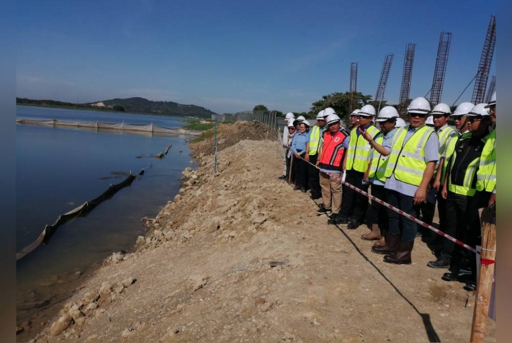 Izham (kanan) meninjau perkembangan projek SJAM babitkan kolam C, Jenderam Hilir pada Khamis.