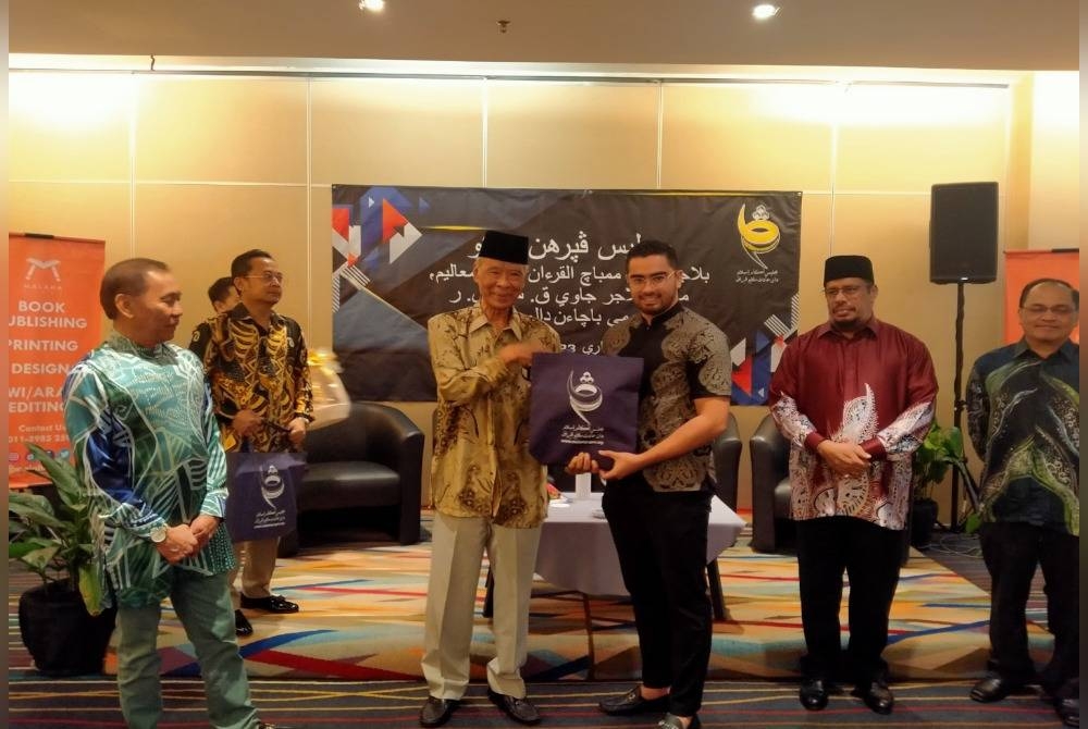 Mohd Annuar (kiri) menyaksikan penyerahan buku-buku pada Majlis Penyerahan Buku Belajar Asas Membaca Al-Quran Kaedah Muallim, Mari Belajar Jawi KSSR dan Fahami Bacaan Dalam Solatmu di sebuah hotel pada Khamis.